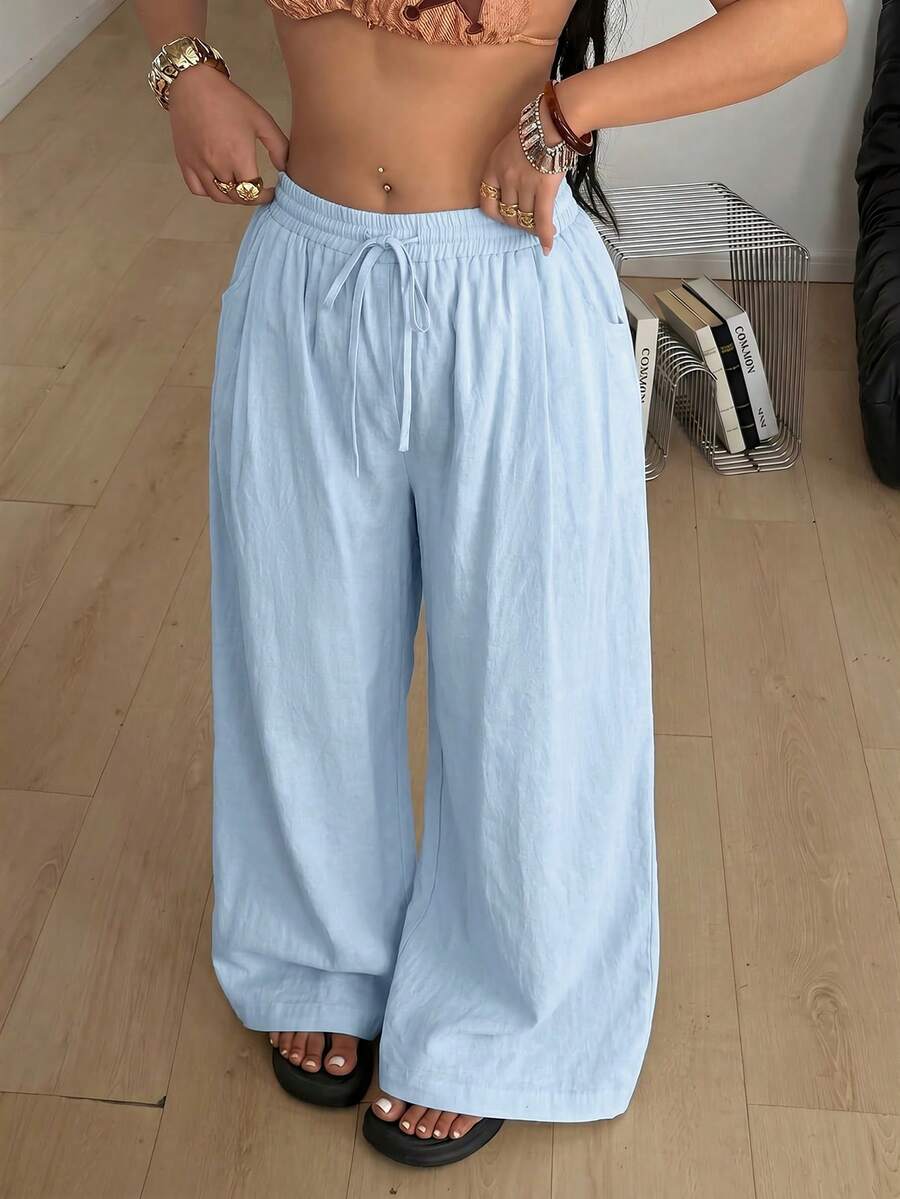 Women's loose straight leg cotton pants featuring a high waist with an adjustable drawstring knot and functional side pockets.