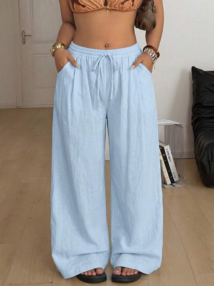 Women's loose straight leg cotton pants featuring a high waist with an adjustable drawstring knot and functional side pockets.