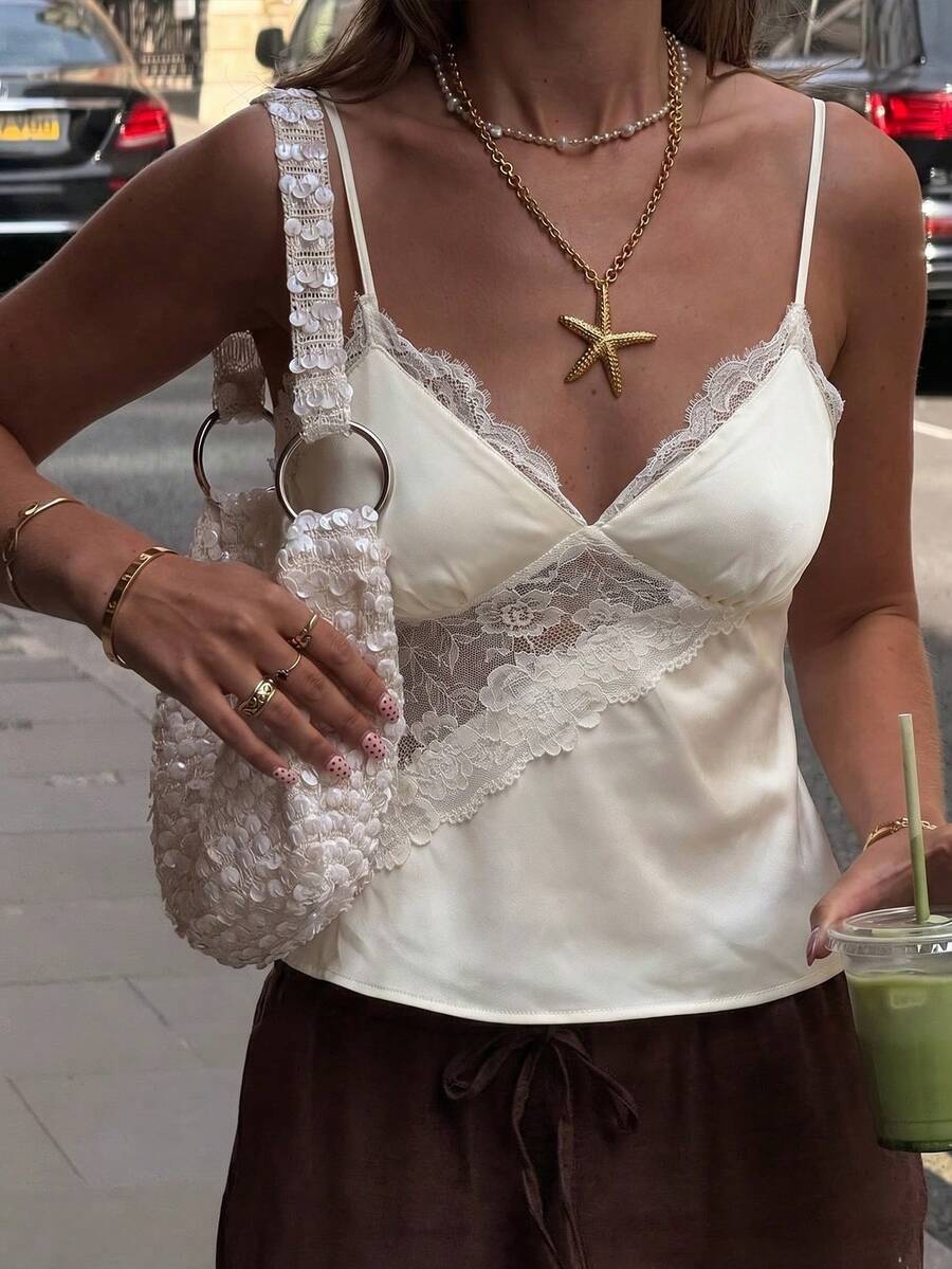 Women's woven spaghetti strap camisole top featuring contrast lace detailing and a regular fit.