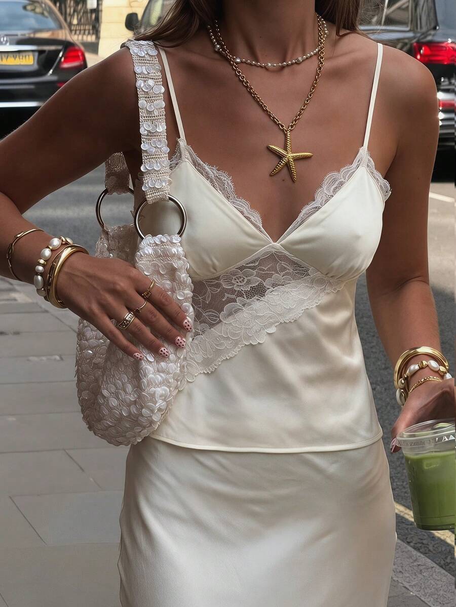 Women's woven spaghetti strap camisole top featuring contrast lace detailing and a regular fit.