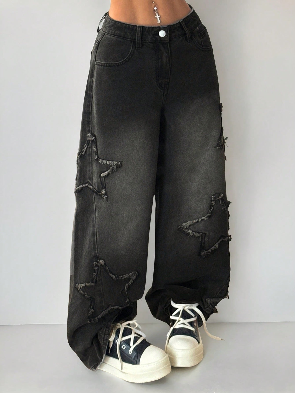 Plus size women's black wide leg denim jeans featuring a mid-waist cut, zipper fly, and distressed ripped detailing.