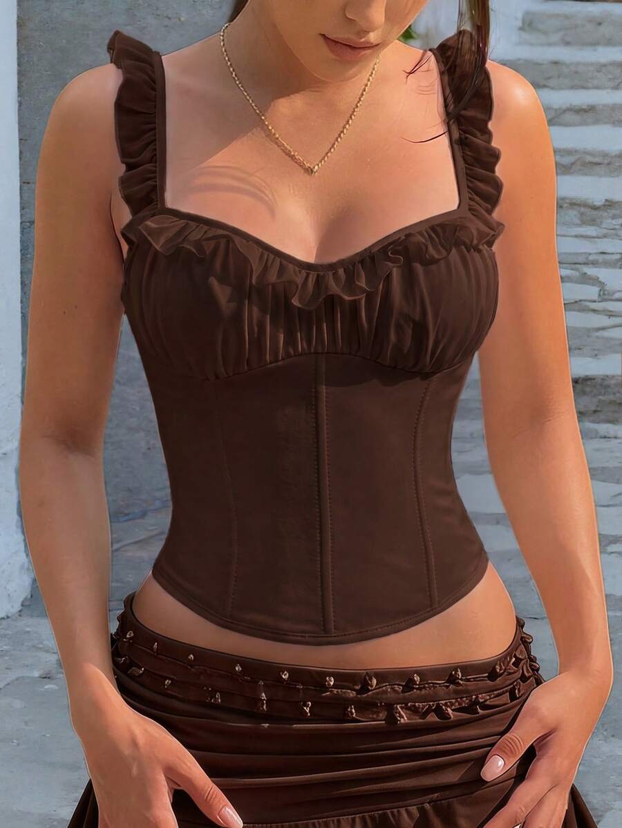 White cropped slim fit camisole top featuring ruffle lettuce trim, lace-up detail, and square neckline.