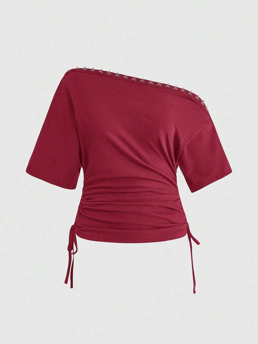Women's slim fit short sleeve t-shirt featuring an asymmetric off-the-shoulder neckline, ruched design, and metal buckle detail.