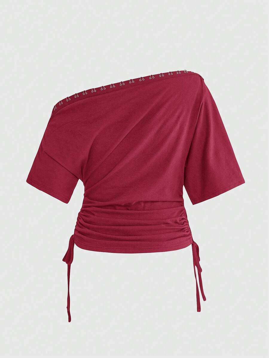 Women's slim fit short sleeve t-shirt featuring an asymmetric off-the-shoulder neckline, ruched design, and metal buckle detail.
