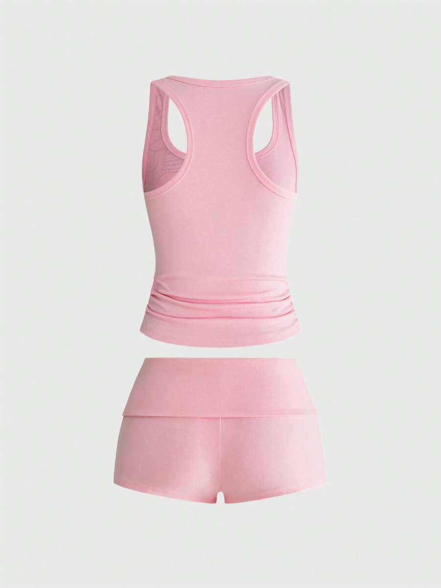 Punk-inspired two-piece set with a fitted scoop neck slogan tank top featuring cross and rhinestone details paired with ultra low waist mini shorts.
