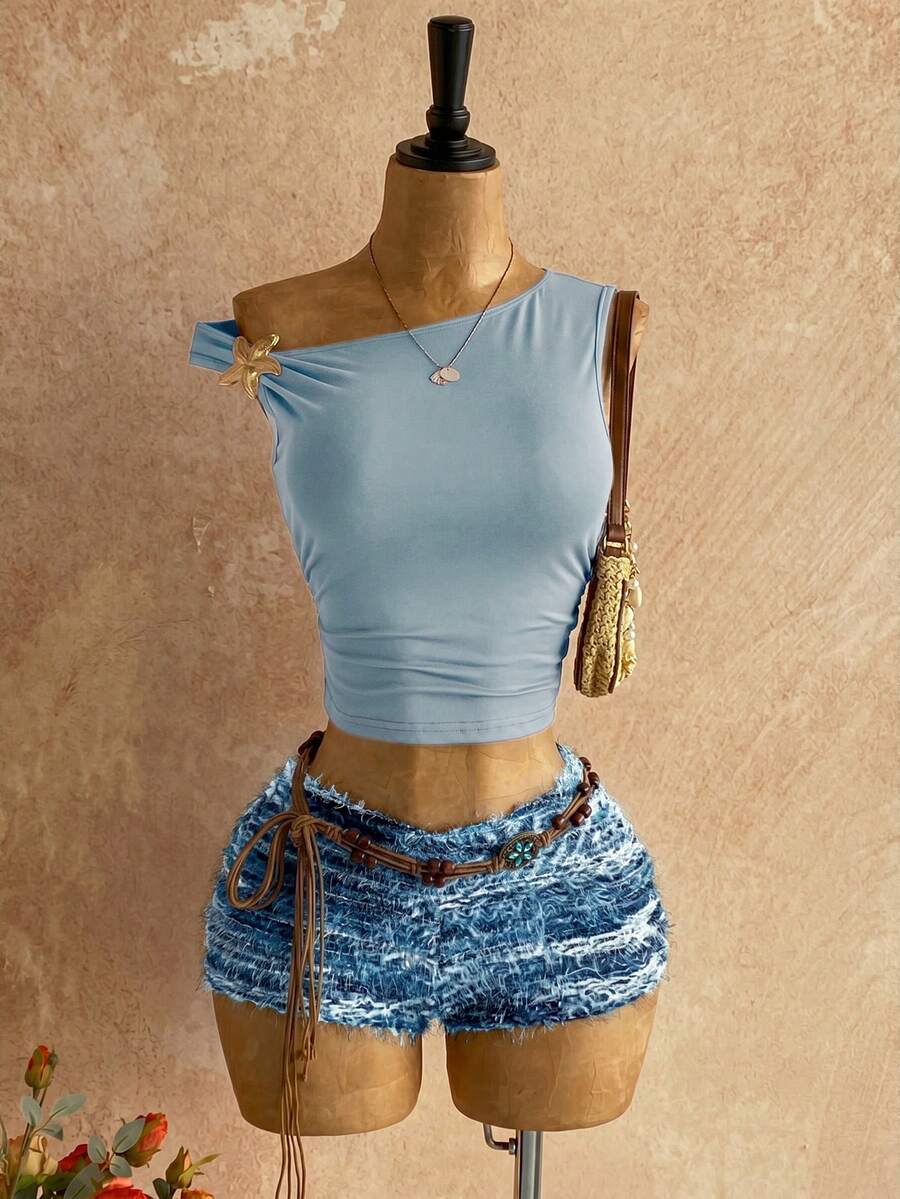 Women's black fuzzy knit two-piece set with an asymmetrical crop camisole top featuring ruched detail and cutout back, paired with matching mini shorts.