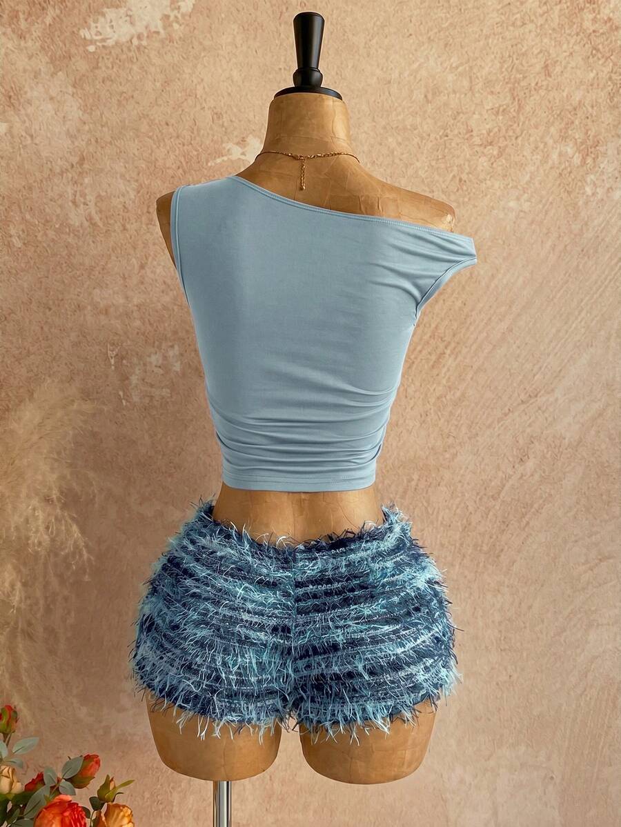 Women's black fuzzy knit two-piece set with an asymmetrical crop camisole top featuring ruched detail and cutout back, paired with matching mini shorts.