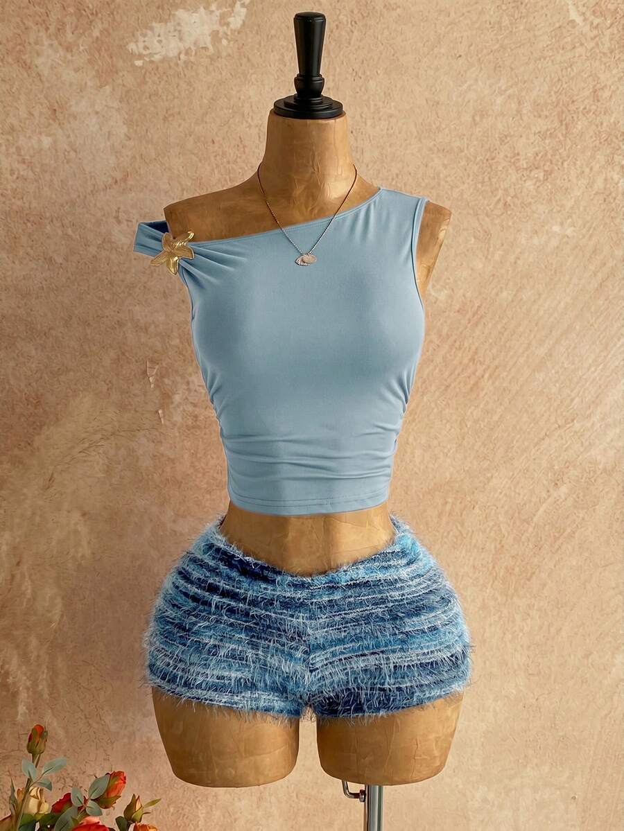 Women's black fuzzy knit two-piece set with an asymmetrical crop camisole top featuring ruched detail and cutout back, paired with matching mini shorts.