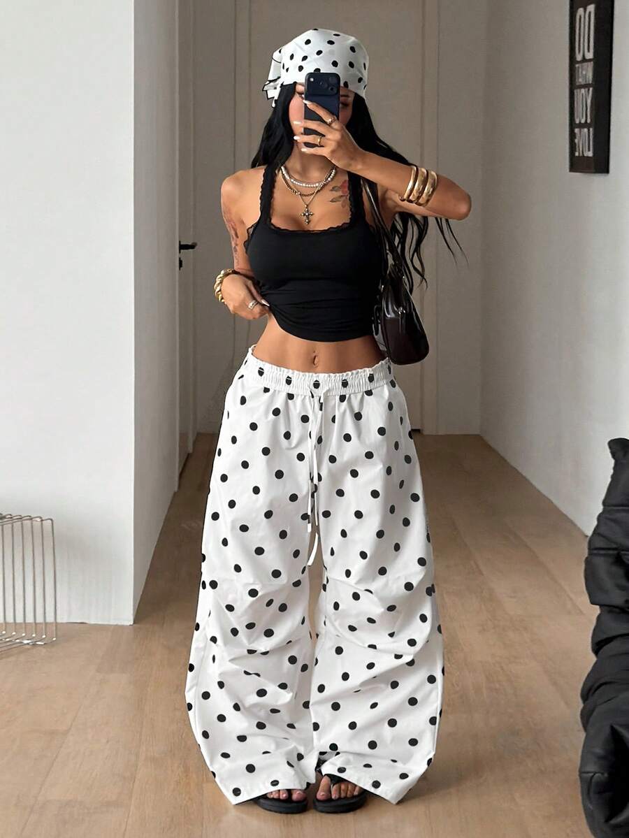 Women's black and white striped wide leg pants featuring an elastic drawstring waistband, side pockets, and a loose straight leg fit.