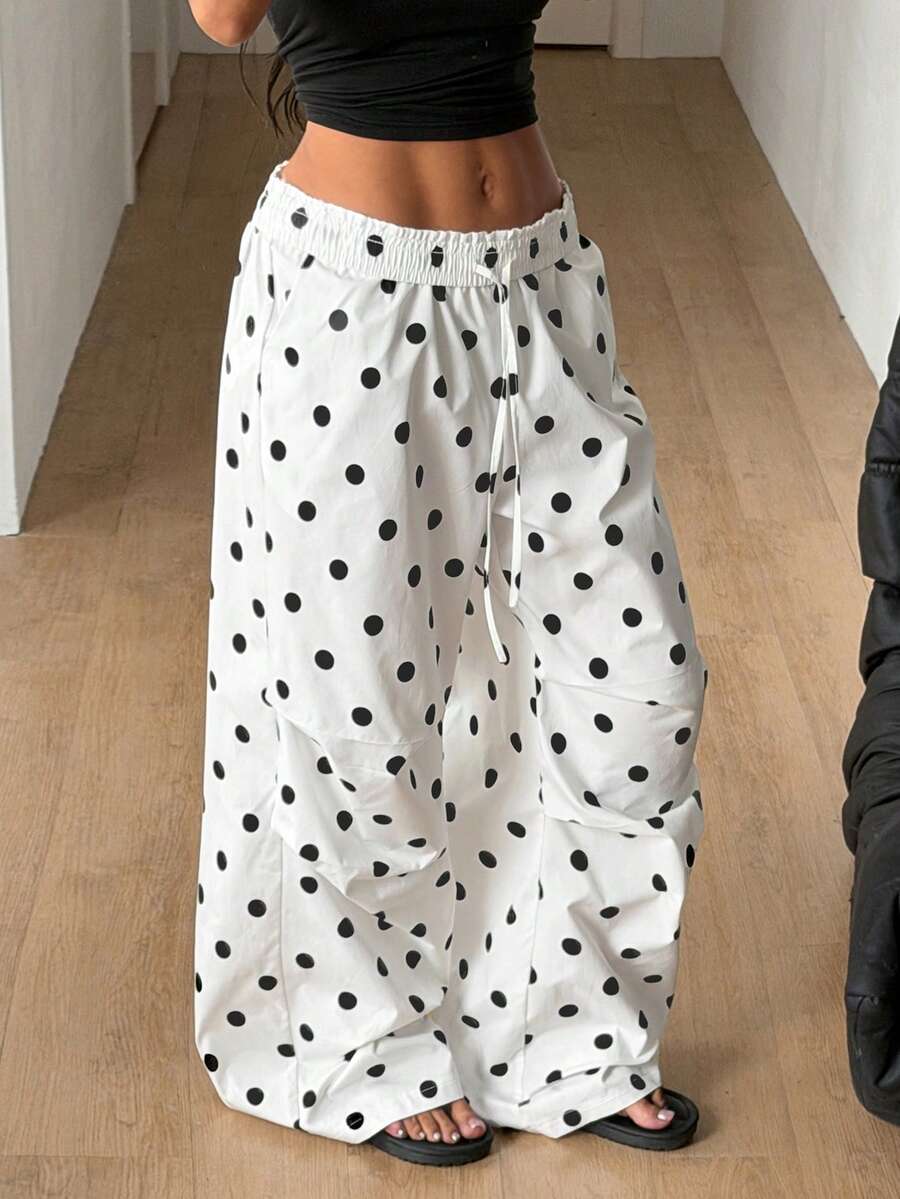 Women's black and white striped wide leg pants featuring an elastic drawstring waistband, side pockets, and a loose straight leg fit.