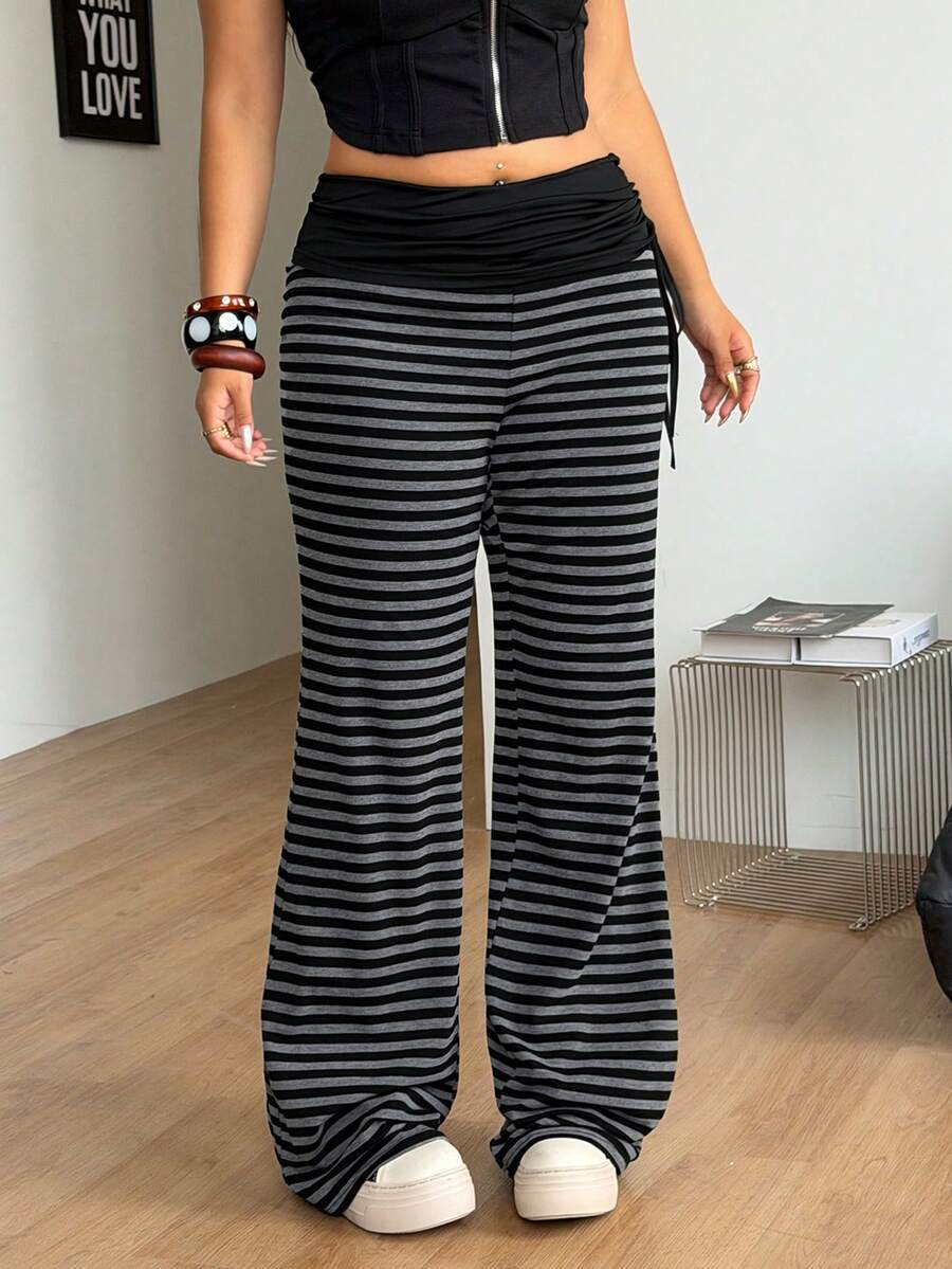 Women's striped flare leg pants featuring a mid-rise waist, slim fit thigh, and ruched side drawstring detail in stretch knit fabric.
