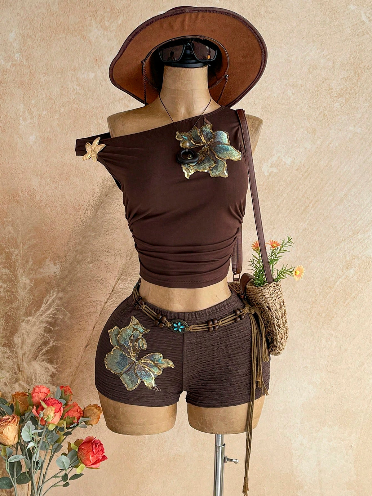 Women's black fuzzy knit two-piece set with an asymmetrical crop camisole top featuring ruched detail and cutout back, paired with matching mini shorts.