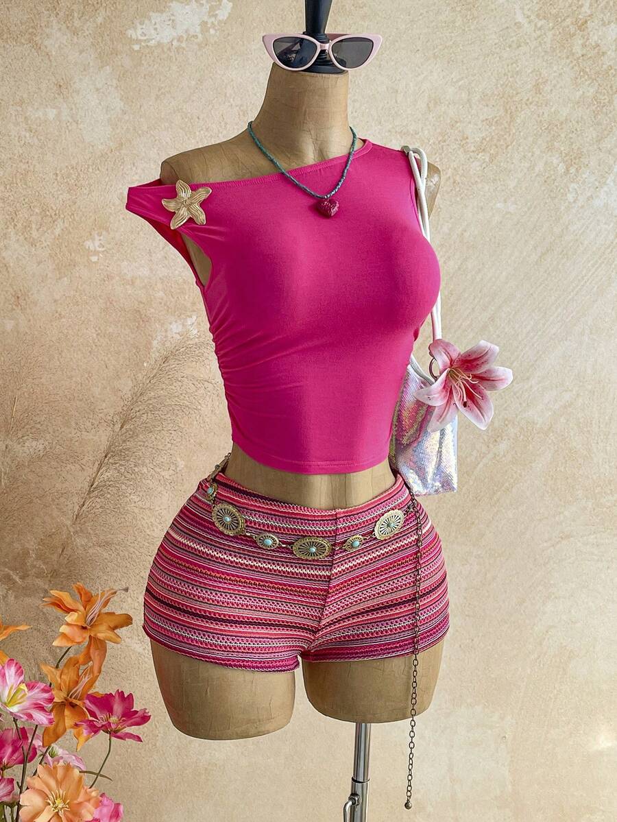 Women's black fuzzy knit two-piece set with an asymmetrical crop camisole top featuring ruched detail and cutout back, paired with matching mini shorts.
