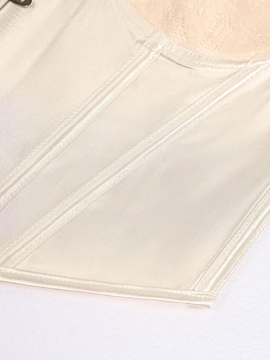Champagne satin lace camisole crop top featuring spaghetti straps, gold front buttons, boned cup details, and a tie-back design.