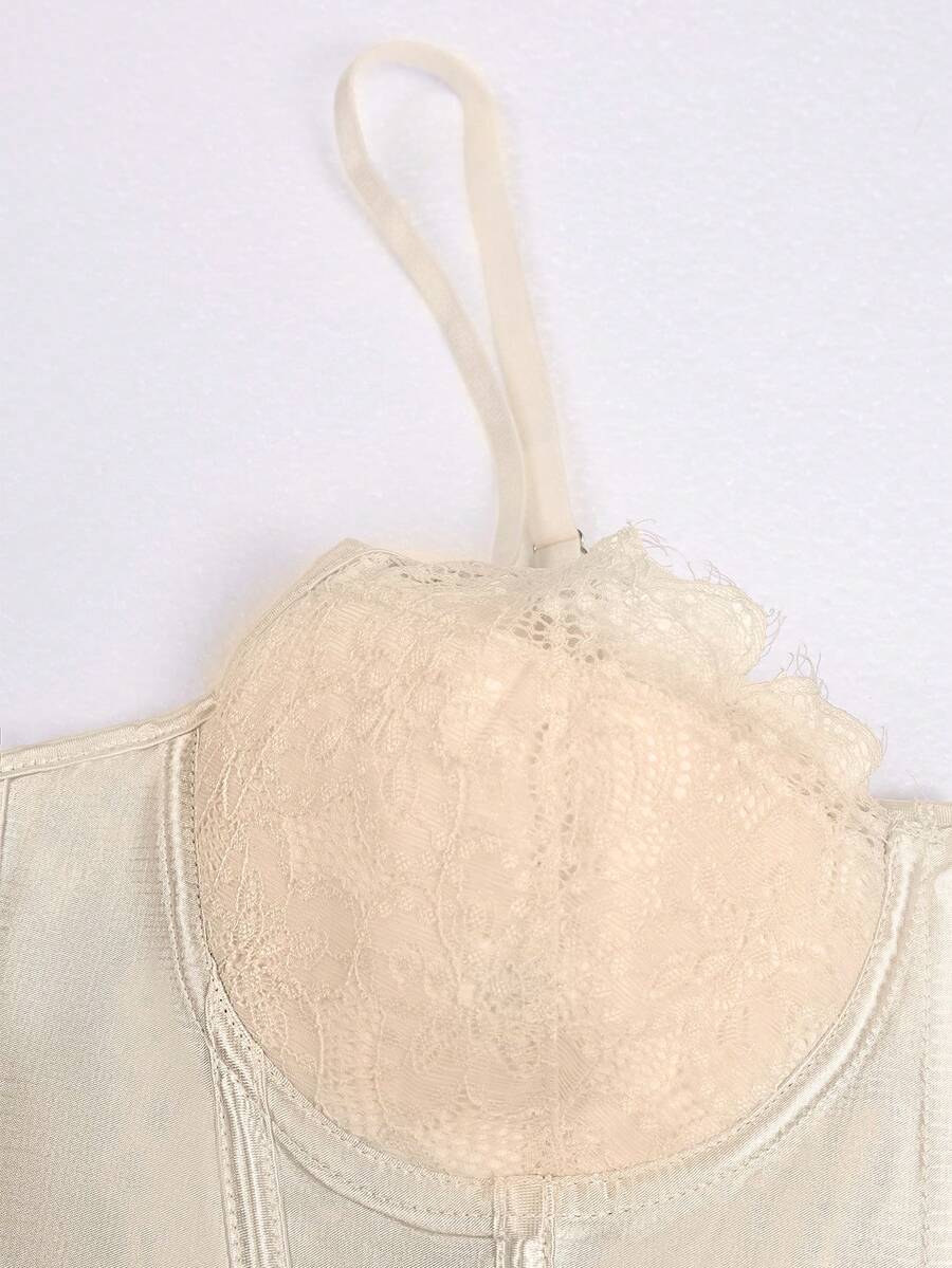 Champagne satin lace camisole crop top featuring spaghetti straps, gold front buttons, boned cup details, and a tie-back design.