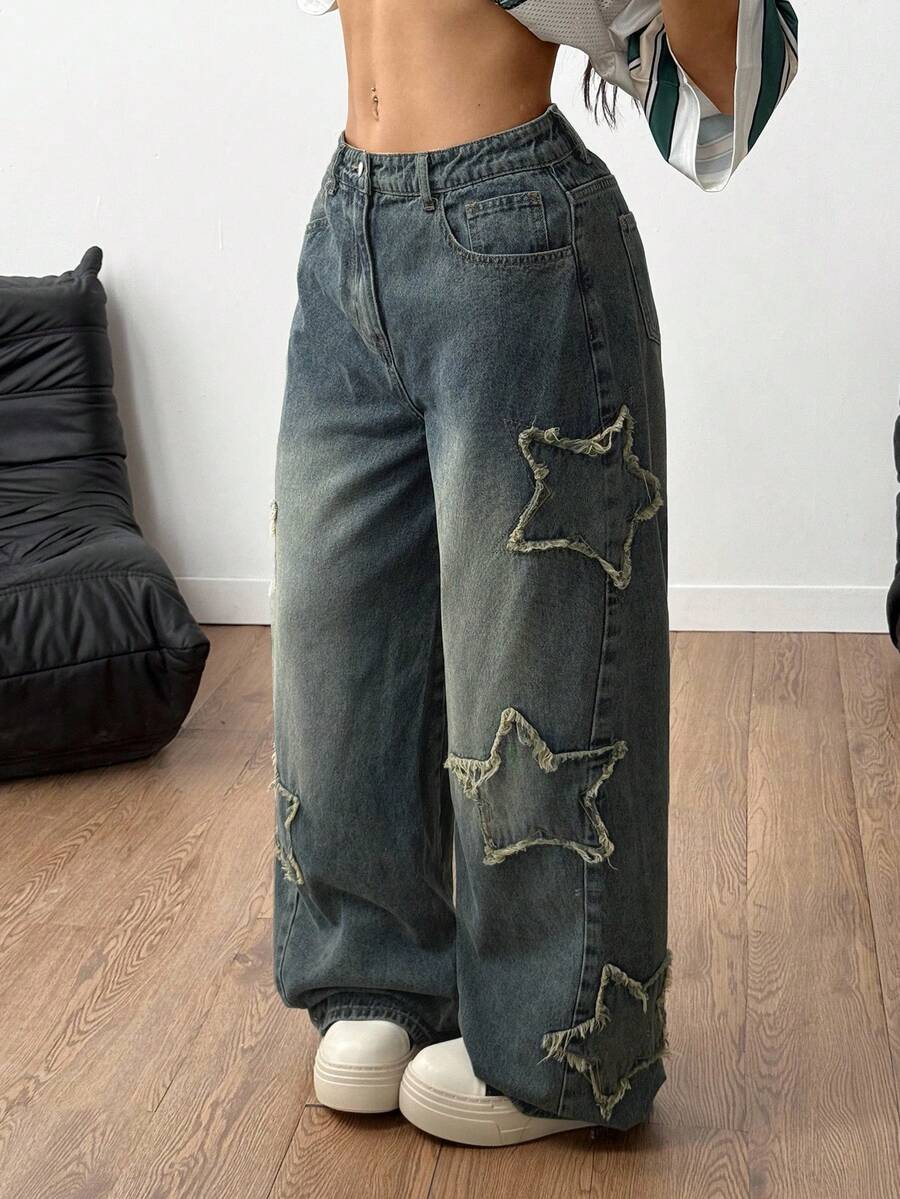 Women's loose fit baggy jeans in washed denim featuring star patches, slant pockets, and a mid-rise cut.