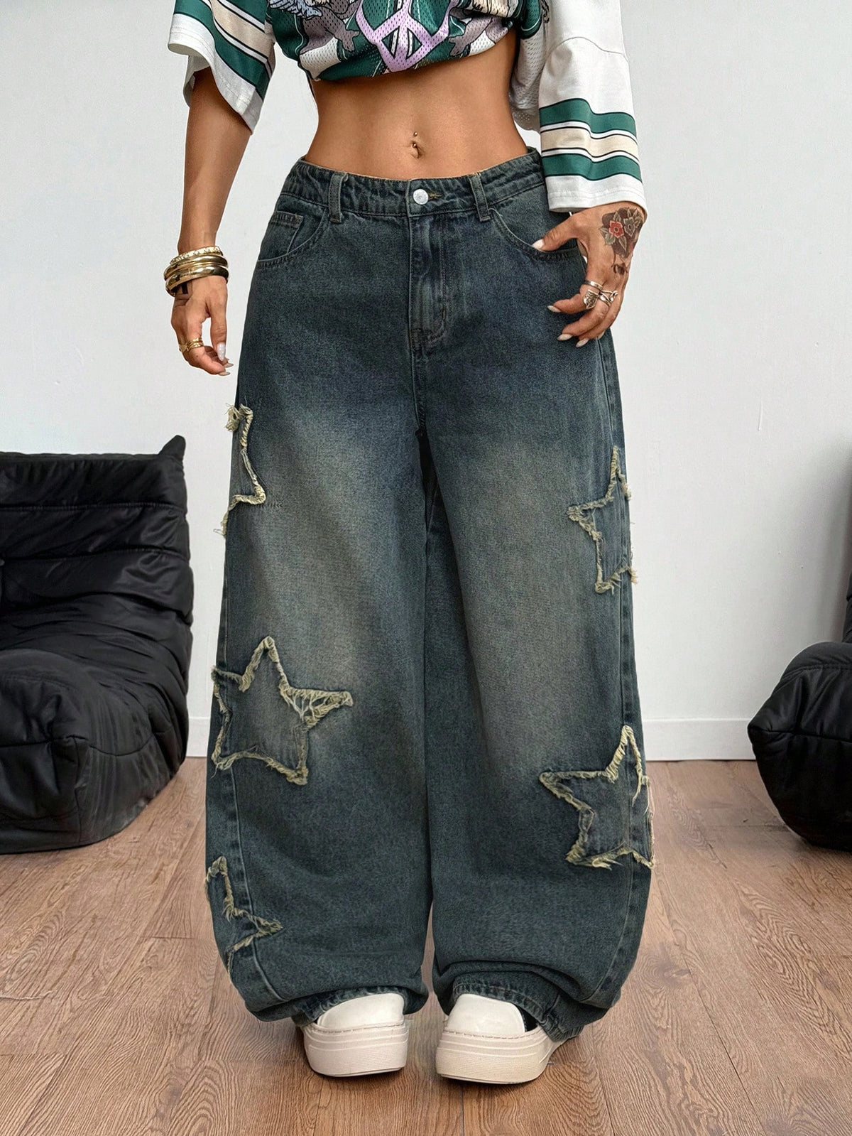 Women's loose fit baggy jeans in washed denim featuring star patches, slant pockets, and a mid-rise cut.