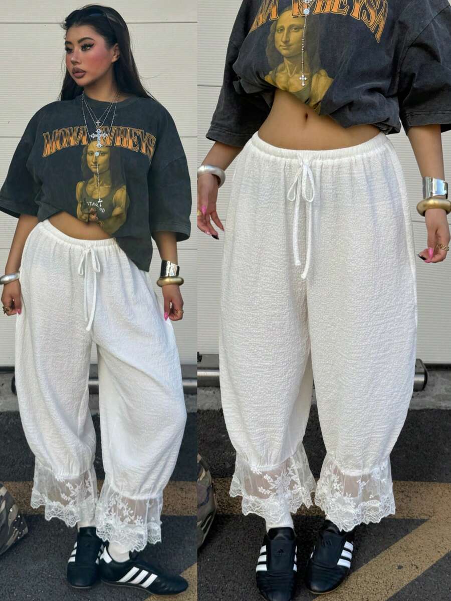 Women's loose-fitting lantern bloomer pants in capri length featuring delicate contrast lace trim and a drawstring waist.