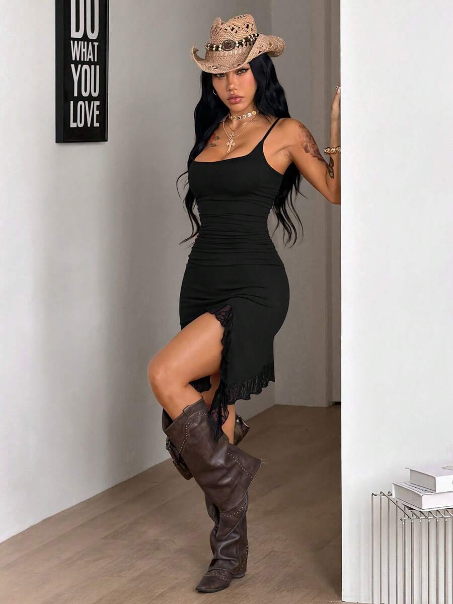 Front view of a women's black sleeveless bustier cami dress featuring spaghetti straps, a slim fit, and an asymmetrical split thigh hem.