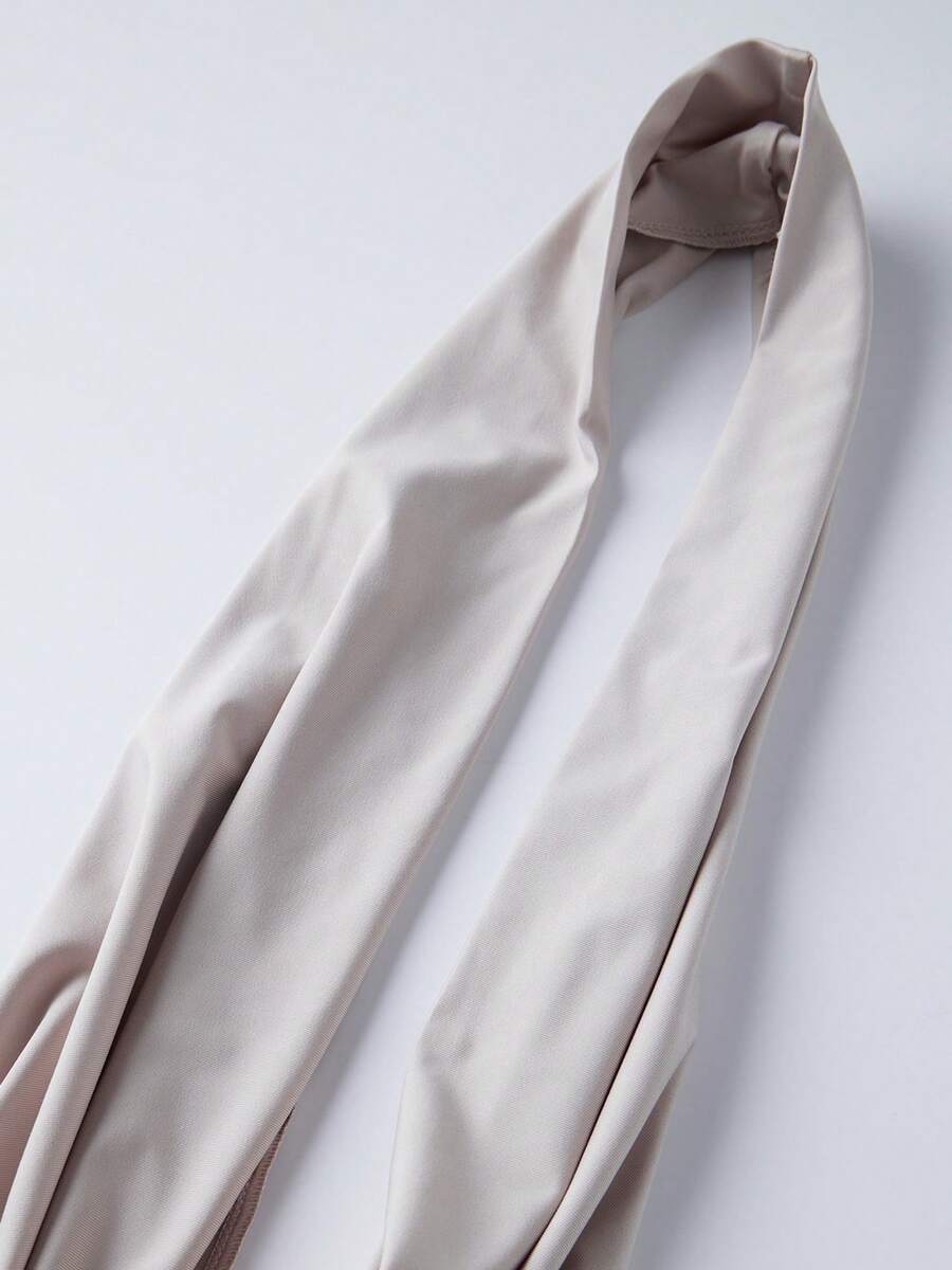 Women's backless halter crop top featuring a draped cowl front, knot detail, and slim fit design.