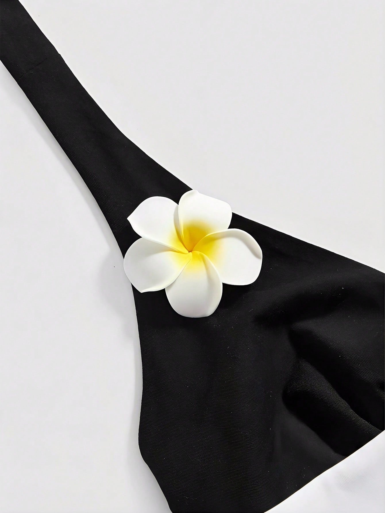 Women's black and white halter neck tank top with ladybug and daisy decor, geometric pattern, ruched front, knot detail, and backless design.