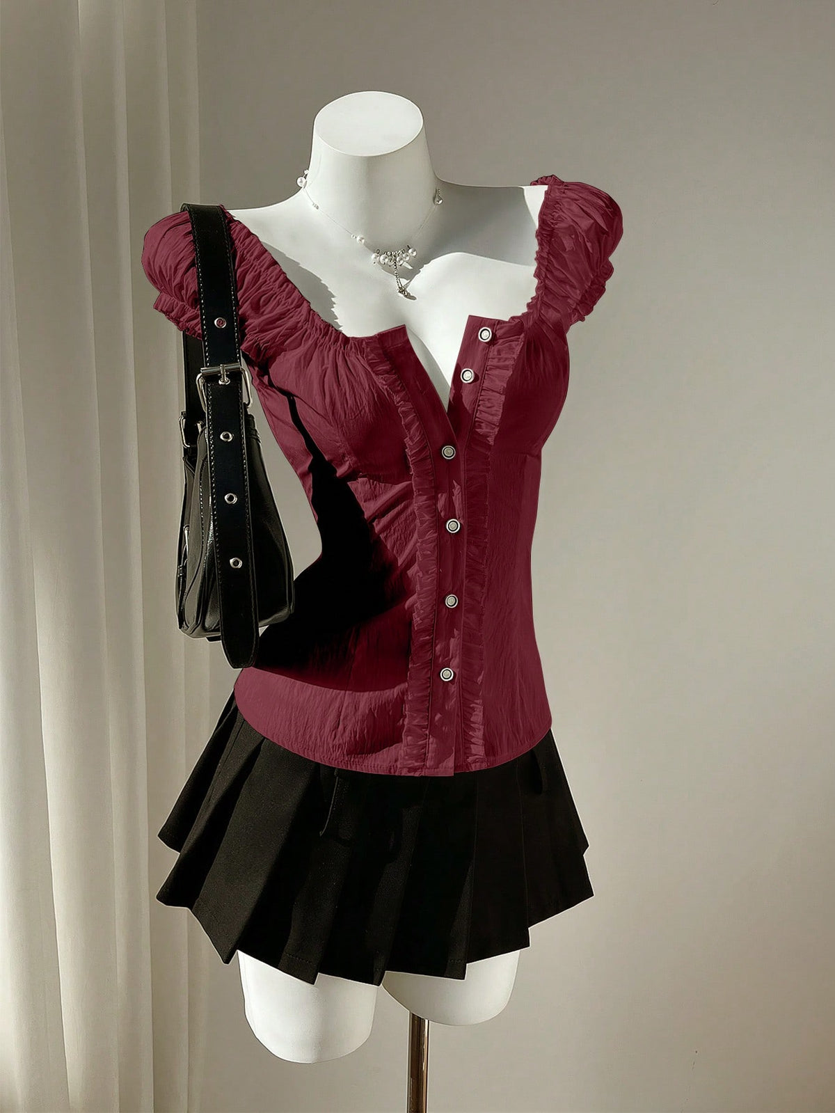 Women's black off-shoulder cap sleeve blouse with ruffled detailing and a tie-back design.