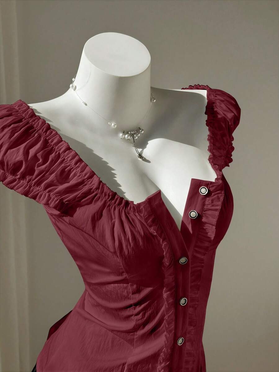 Women's black off-shoulder cap sleeve blouse with ruffled detailing and a tie-back design.
