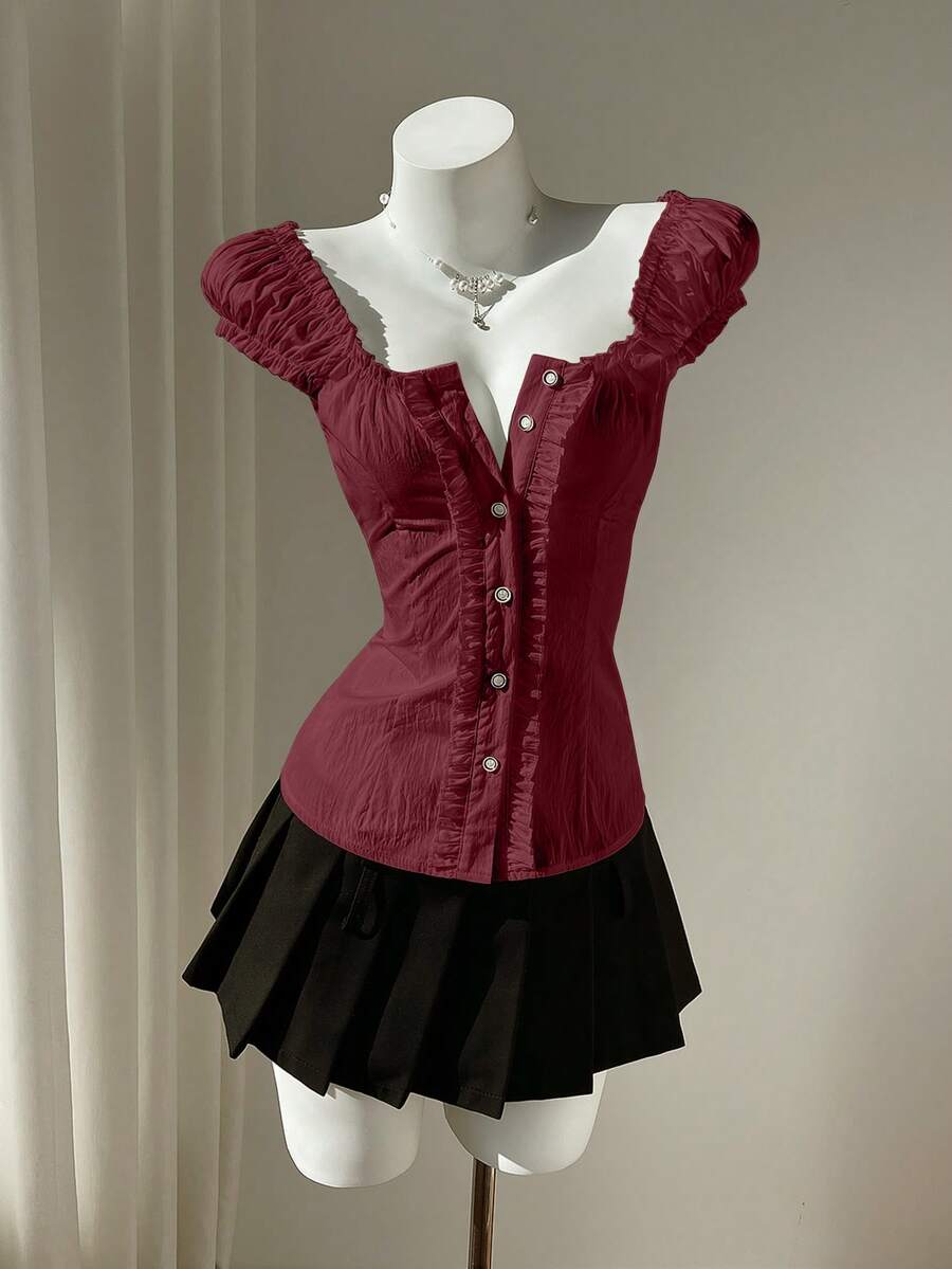 Women's black off-shoulder cap sleeve blouse with ruffled detailing and a tie-back design.