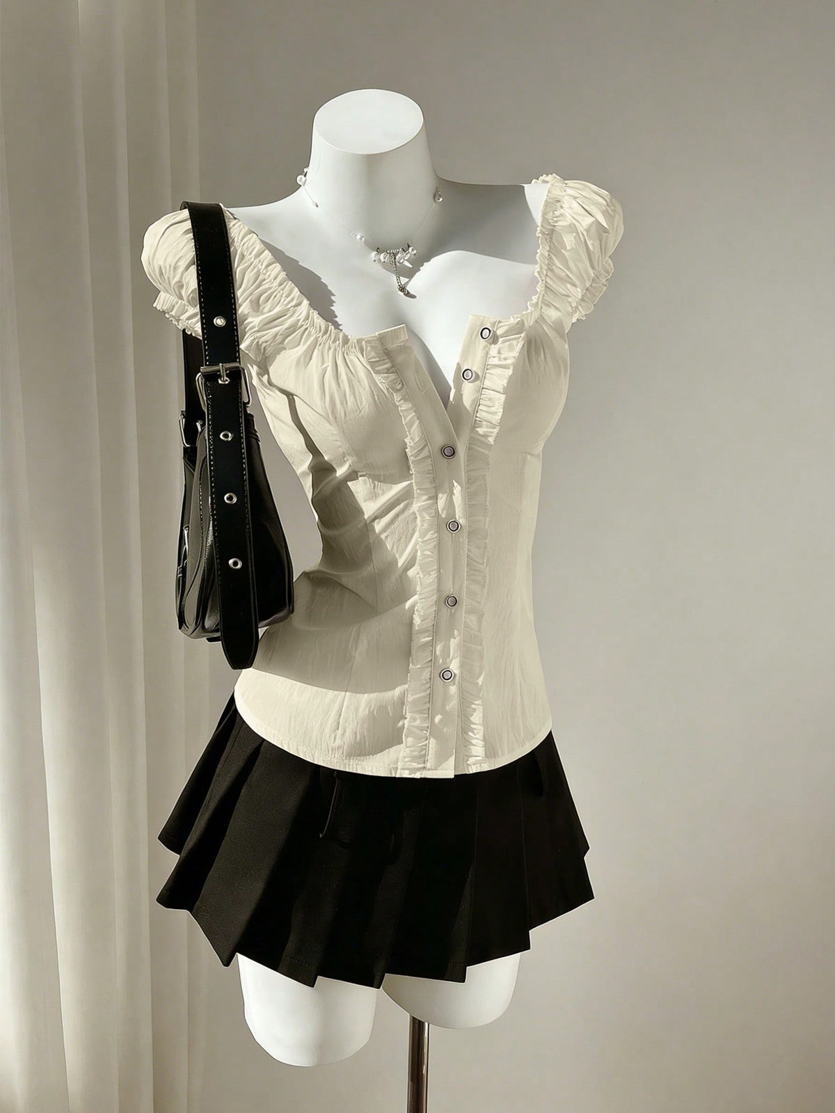 Women's black off-shoulder cap sleeve blouse with ruffled detailing and a tie-back design.
