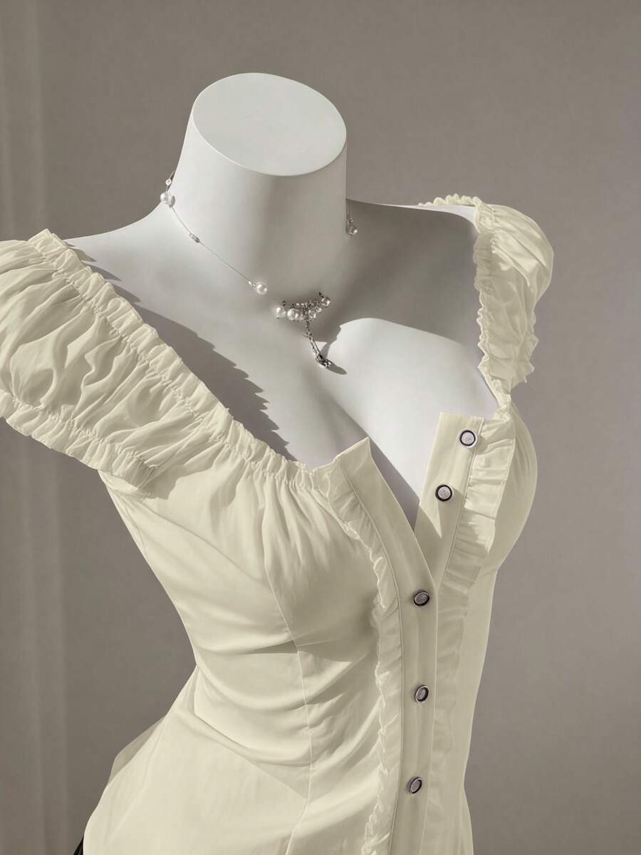 Women's black off-shoulder cap sleeve blouse with ruffled detailing and a tie-back design.