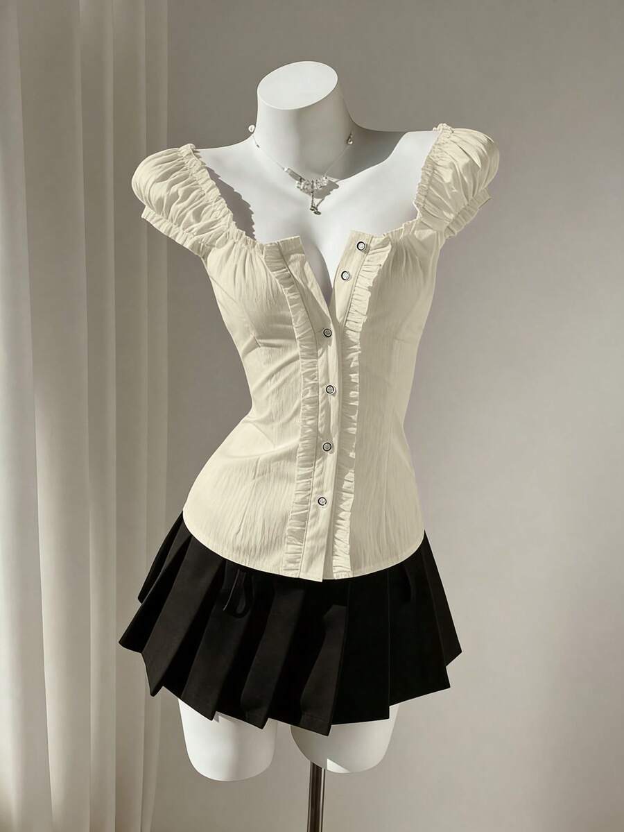 Women's black off-shoulder cap sleeve blouse with ruffled detailing and a tie-back design.