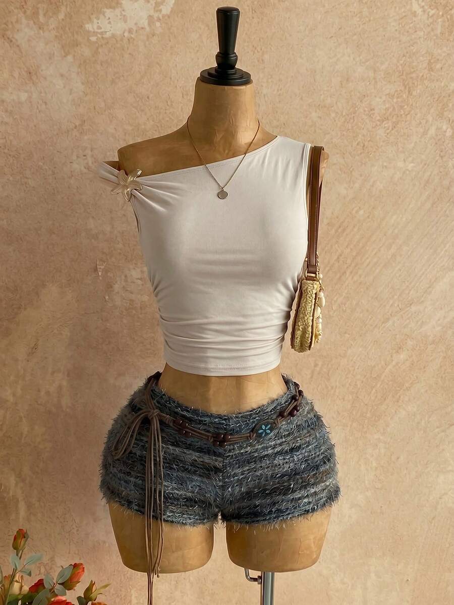 Women's black fuzzy knit two-piece set with an asymmetrical crop camisole top featuring ruched detail and cutout back, paired with matching mini shorts.