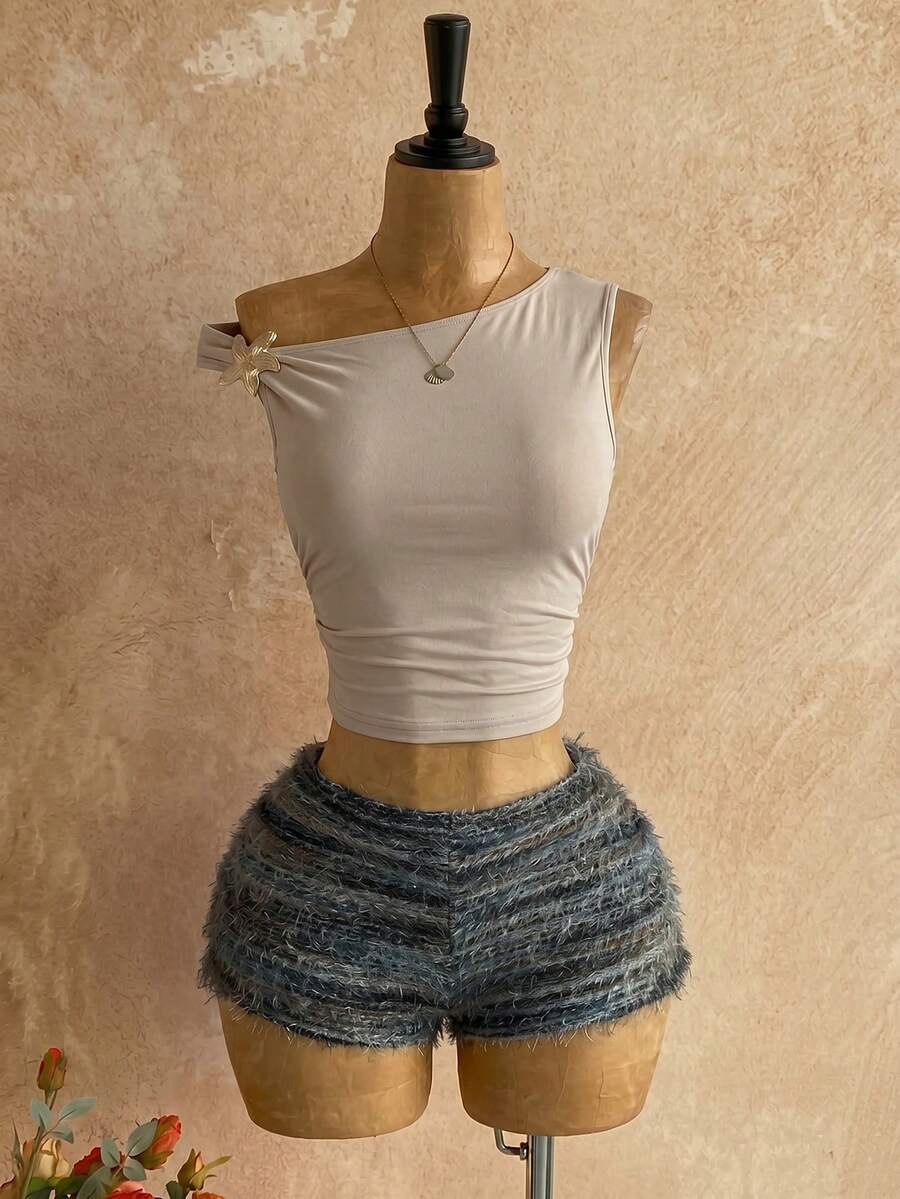 Women's black fuzzy knit two-piece set with an asymmetrical crop camisole top featuring ruched detail and cutout back, paired with matching mini shorts.
