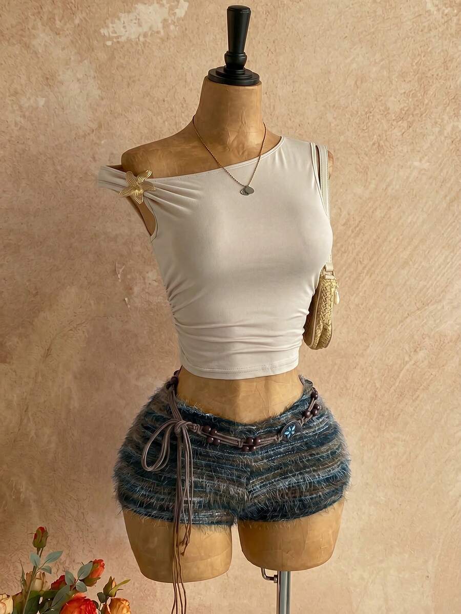 Women's black fuzzy knit two-piece set with an asymmetrical crop camisole top featuring ruched detail and cutout back, paired with matching mini shorts.