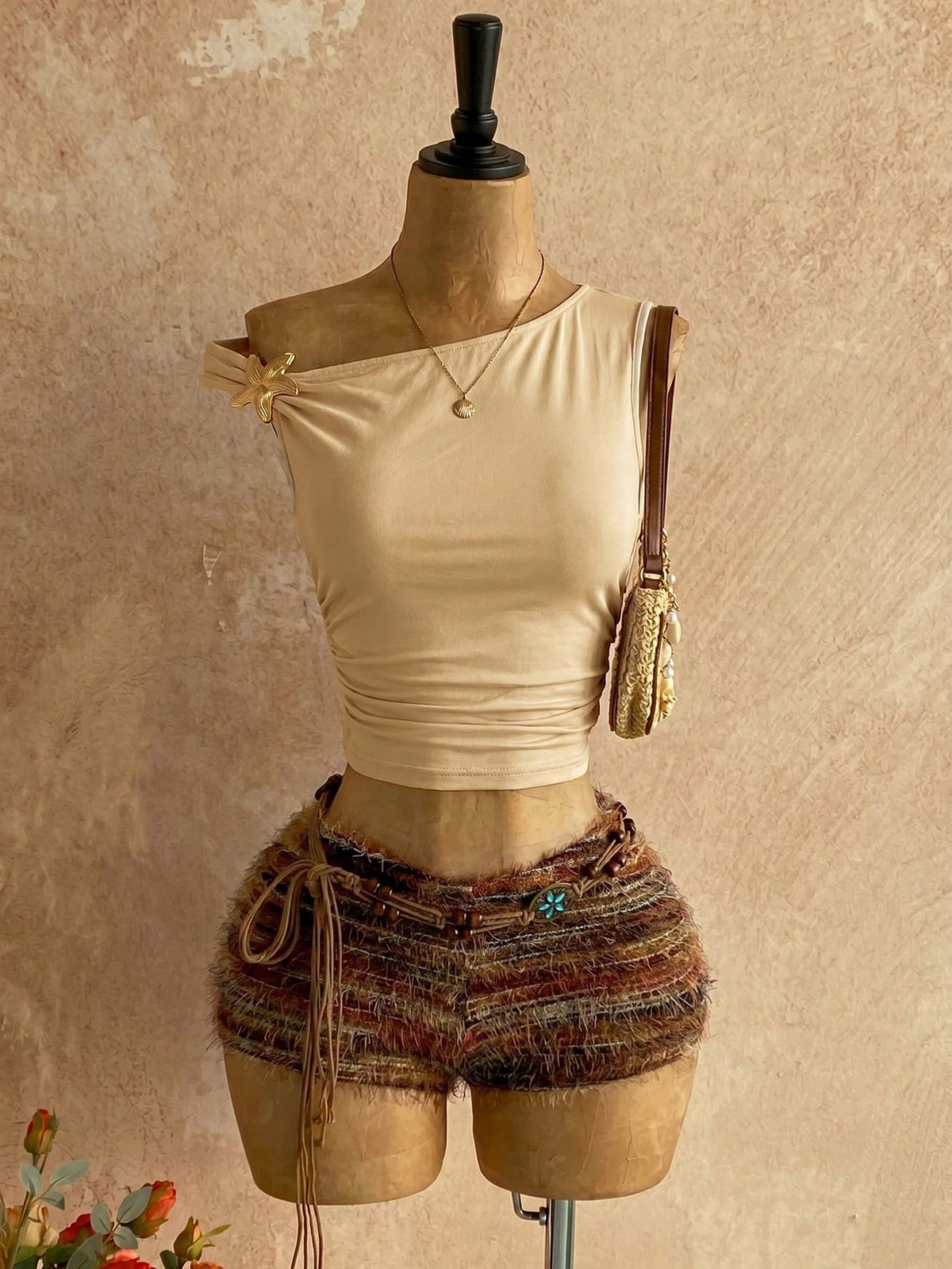 Women's black fuzzy knit two-piece set with an asymmetrical crop camisole top featuring ruched detail and cutout back, paired with matching mini shorts.