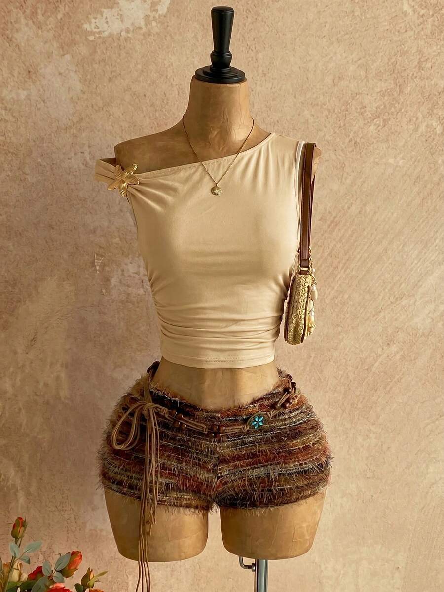 Women's black fuzzy knit two-piece set with an asymmetrical crop camisole top featuring ruched detail and cutout back, paired with matching mini shorts.