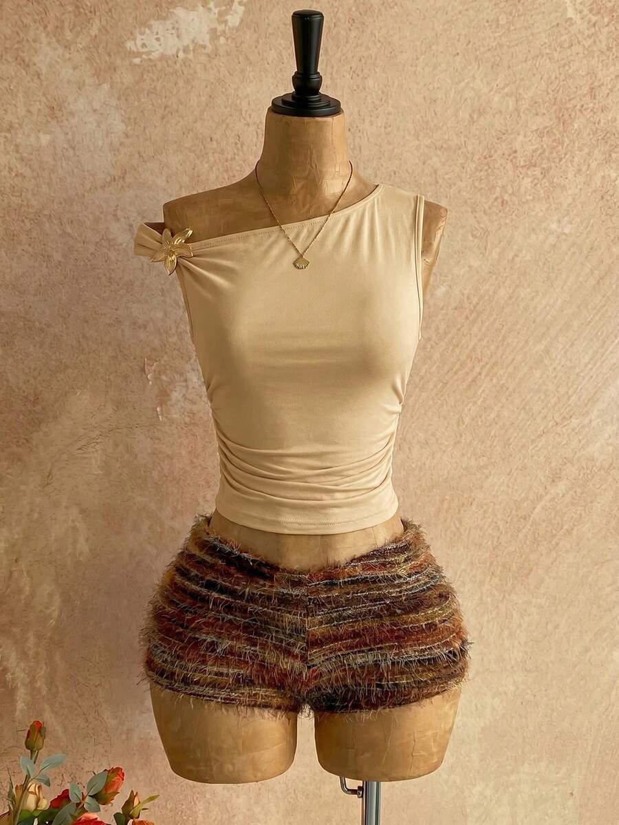 Women's black fuzzy knit two-piece set with an asymmetrical crop camisole top featuring ruched detail and cutout back, paired with matching mini shorts.