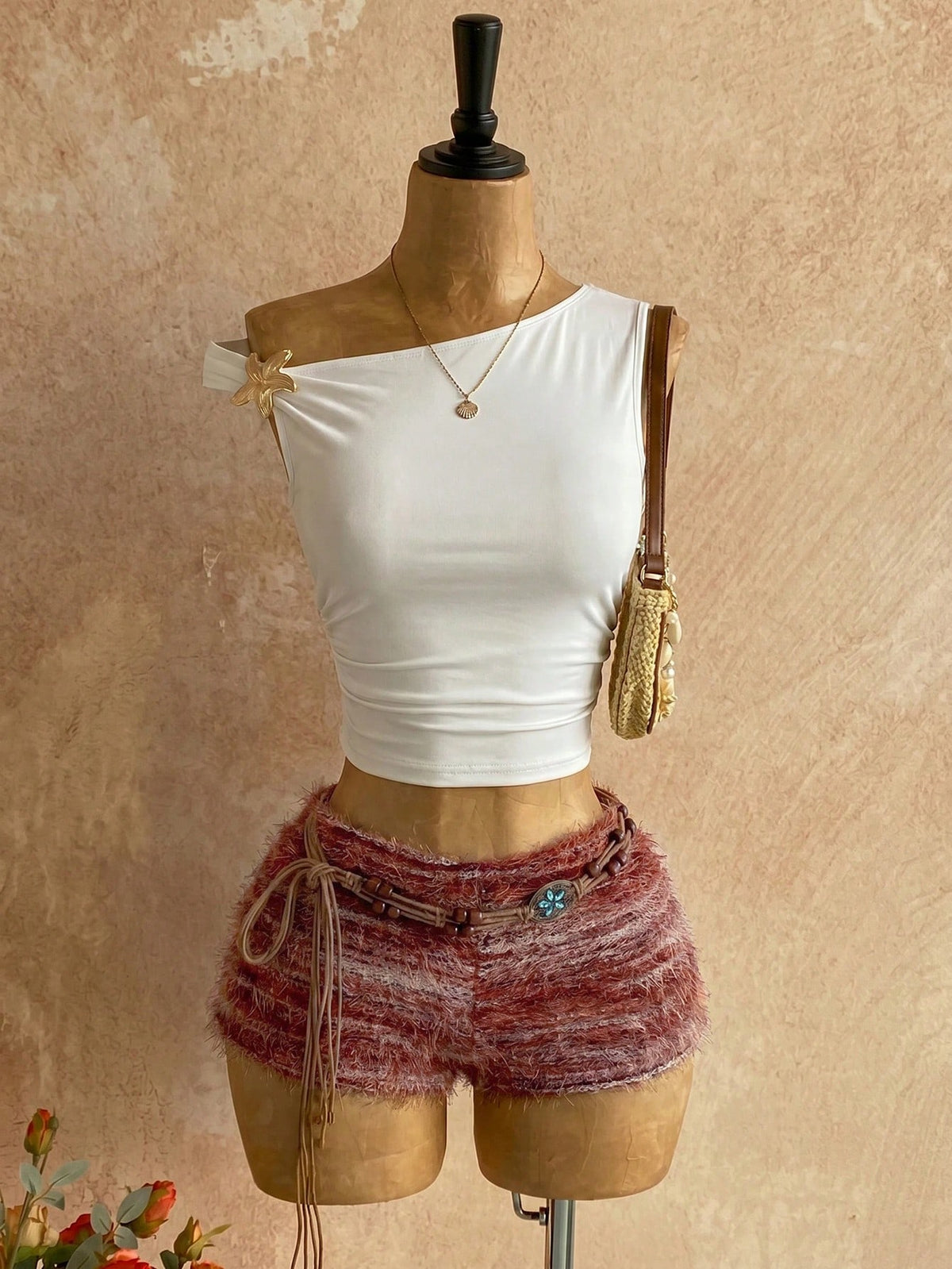 Women's black fuzzy knit two-piece set with an asymmetrical crop camisole top featuring ruched detail and cutout back, paired with matching mini shorts.
