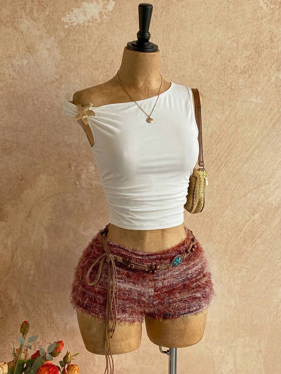 Women's black fuzzy knit two-piece set with an asymmetrical crop camisole top featuring ruched detail and cutout back, paired with matching mini shorts.