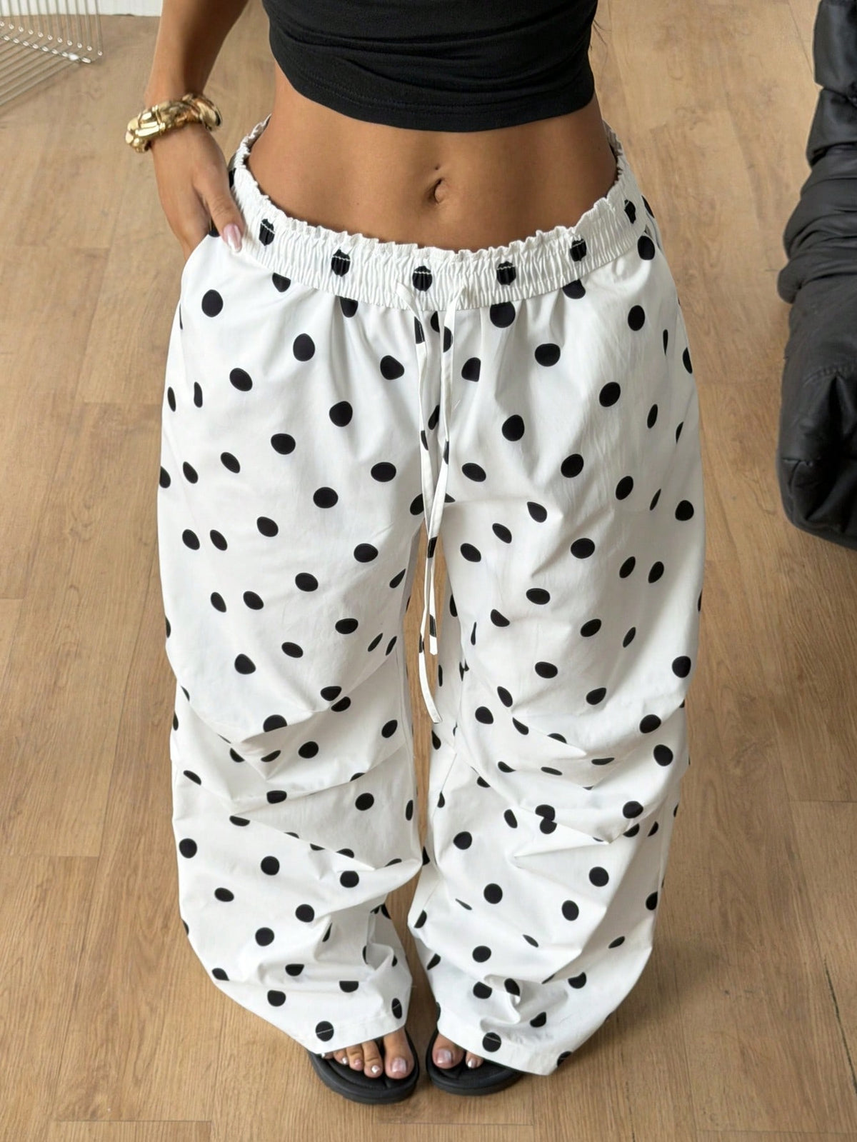 Women's black and white striped wide leg pants featuring an elastic drawstring waistband, side pockets, and a loose straight leg fit.