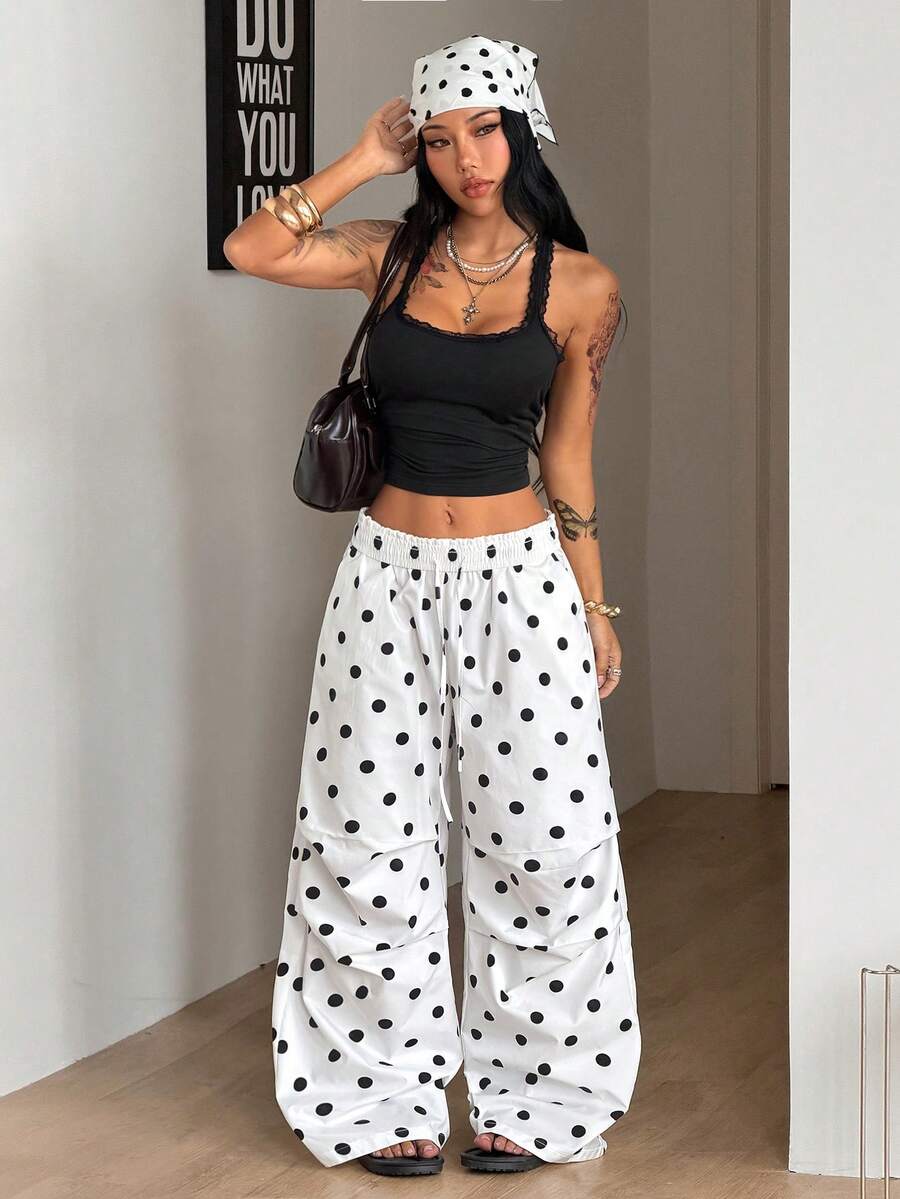 Women's black and white striped wide leg pants featuring an elastic drawstring waistband, side pockets, and a loose straight leg fit.