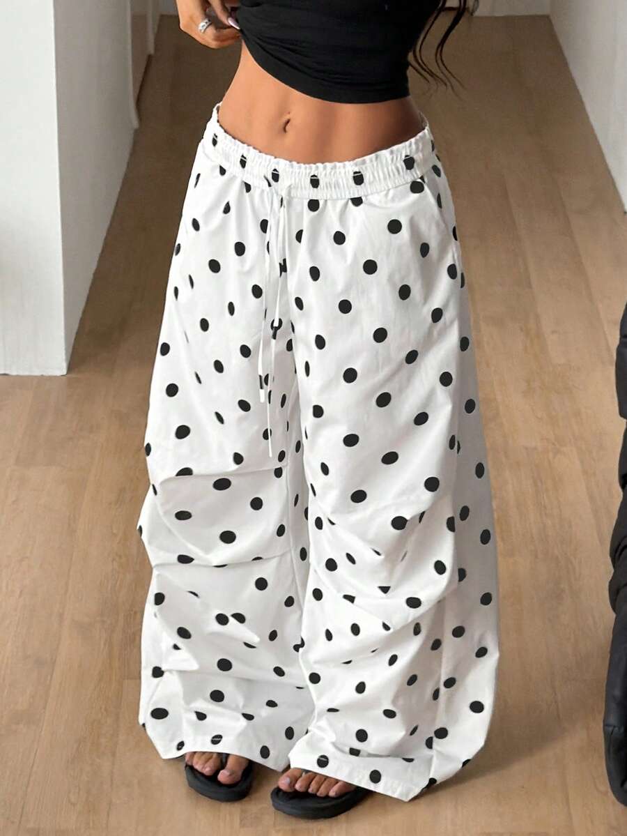 Women's black and white striped wide leg pants featuring an elastic drawstring waistband, side pockets, and a loose straight leg fit.