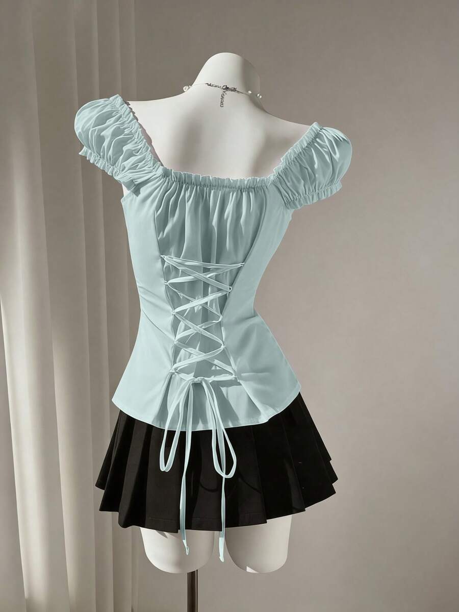 Women's black off-shoulder cap sleeve blouse with ruffled detailing and a tie-back design.