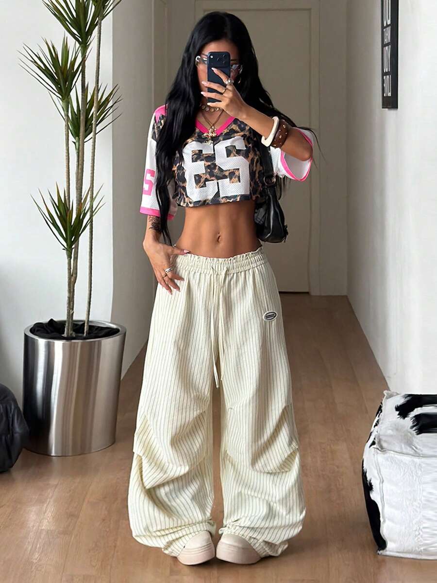 Women's black and white striped wide leg pants featuring an elastic drawstring waistband, side pockets, and a loose straight leg fit.