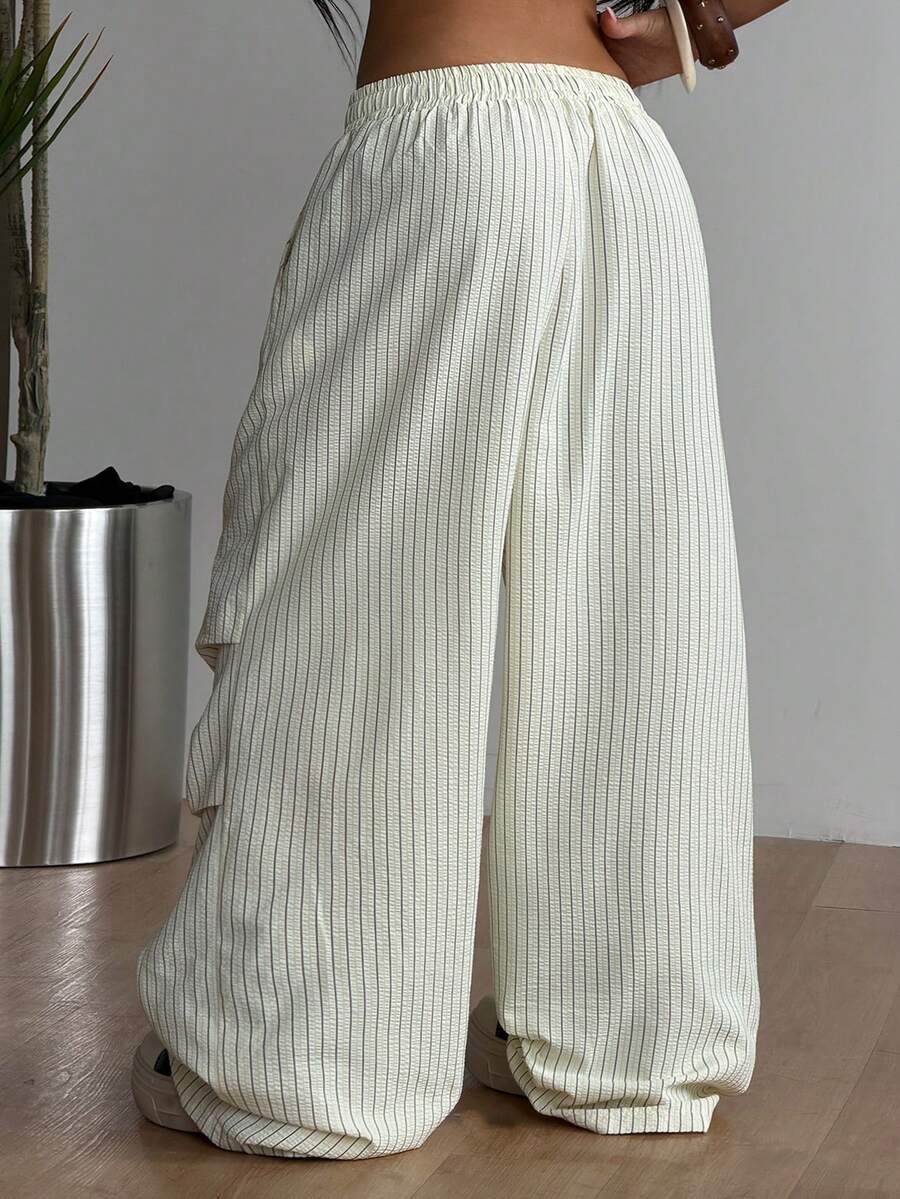 Women's black and white striped wide leg pants featuring an elastic drawstring waistband, side pockets, and a loose straight leg fit.