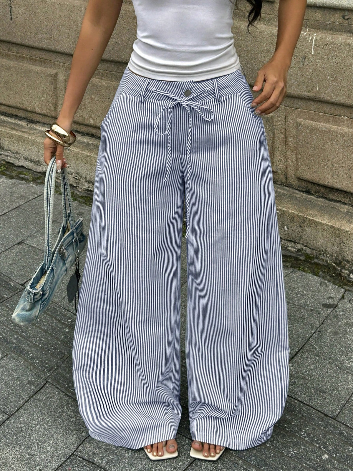 Women's casual straight leg striped woven pants featuring a low waist and zipper fly closure.