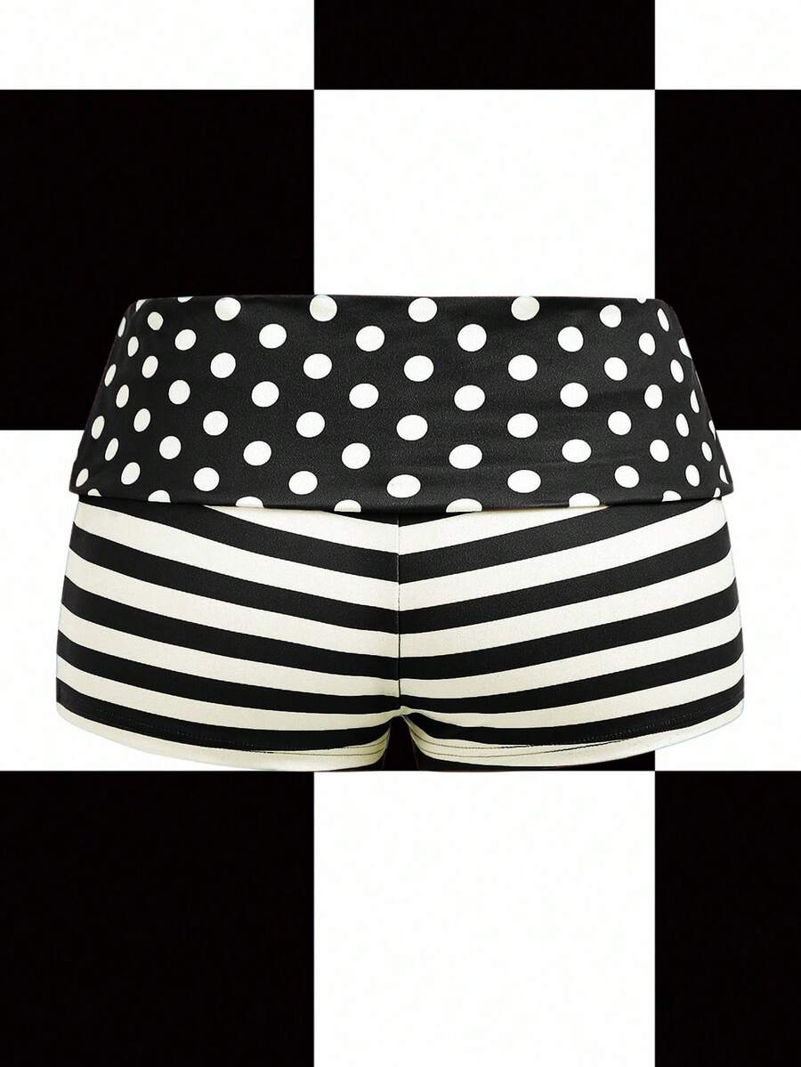 Women's black low waist mini track shorts with contrast polka dot, striped, geometric, and plant-inspired print details, elastic waistband, and skinny fit