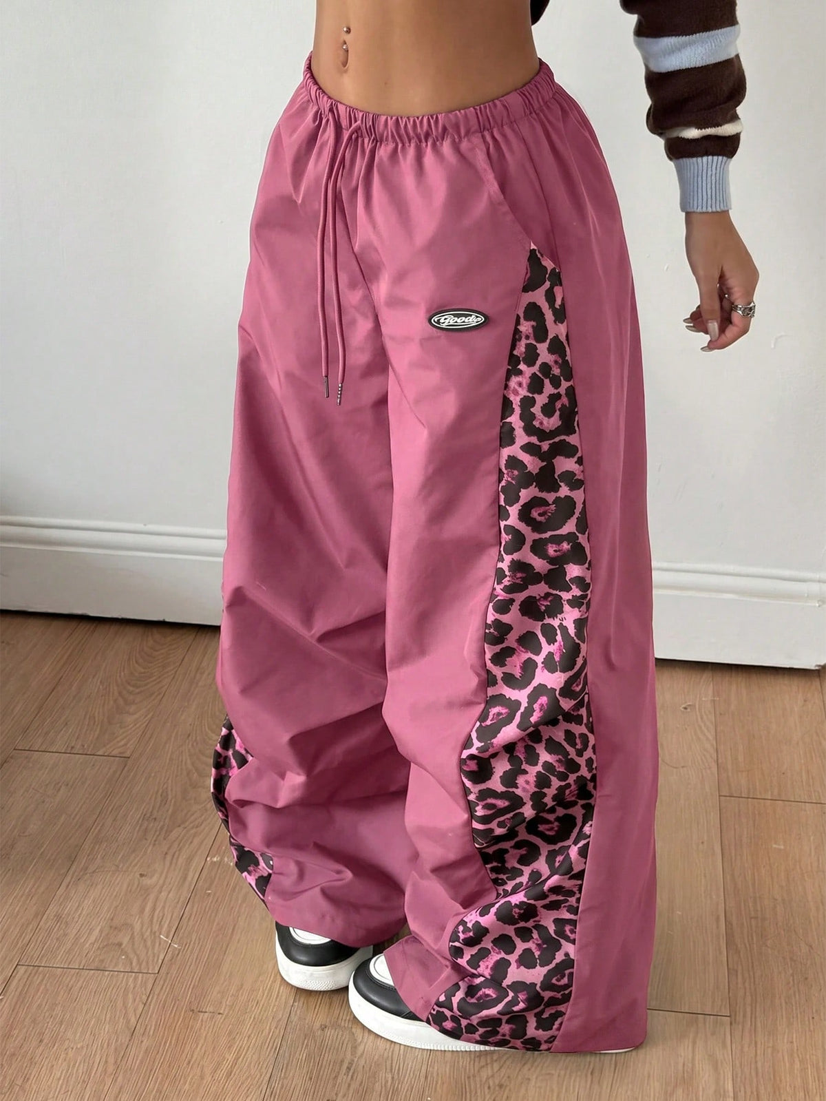 Women's high waist wide leg pants in black featuring leopard print patchwork details and an elastic drawstring waistband.