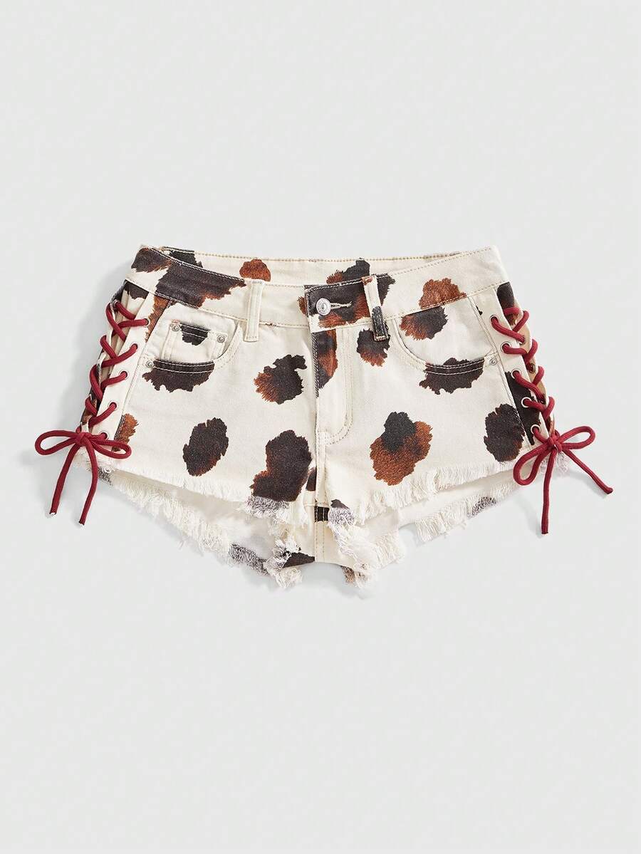 Women's Y2K low waist camo mini skort shorts featuring lace-up knot details, grommet eyelets, graphic lettering pattern, and a zipper fly.