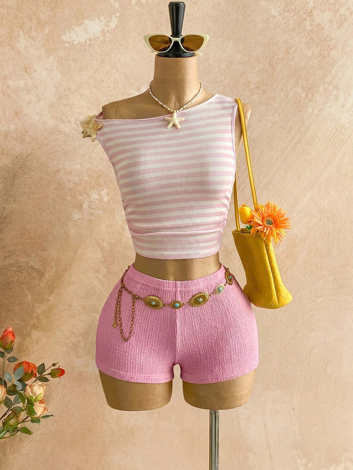 Women's black fuzzy knit two-piece set with an asymmetrical crop camisole top featuring ruched detail and cutout back, paired with matching mini shorts.